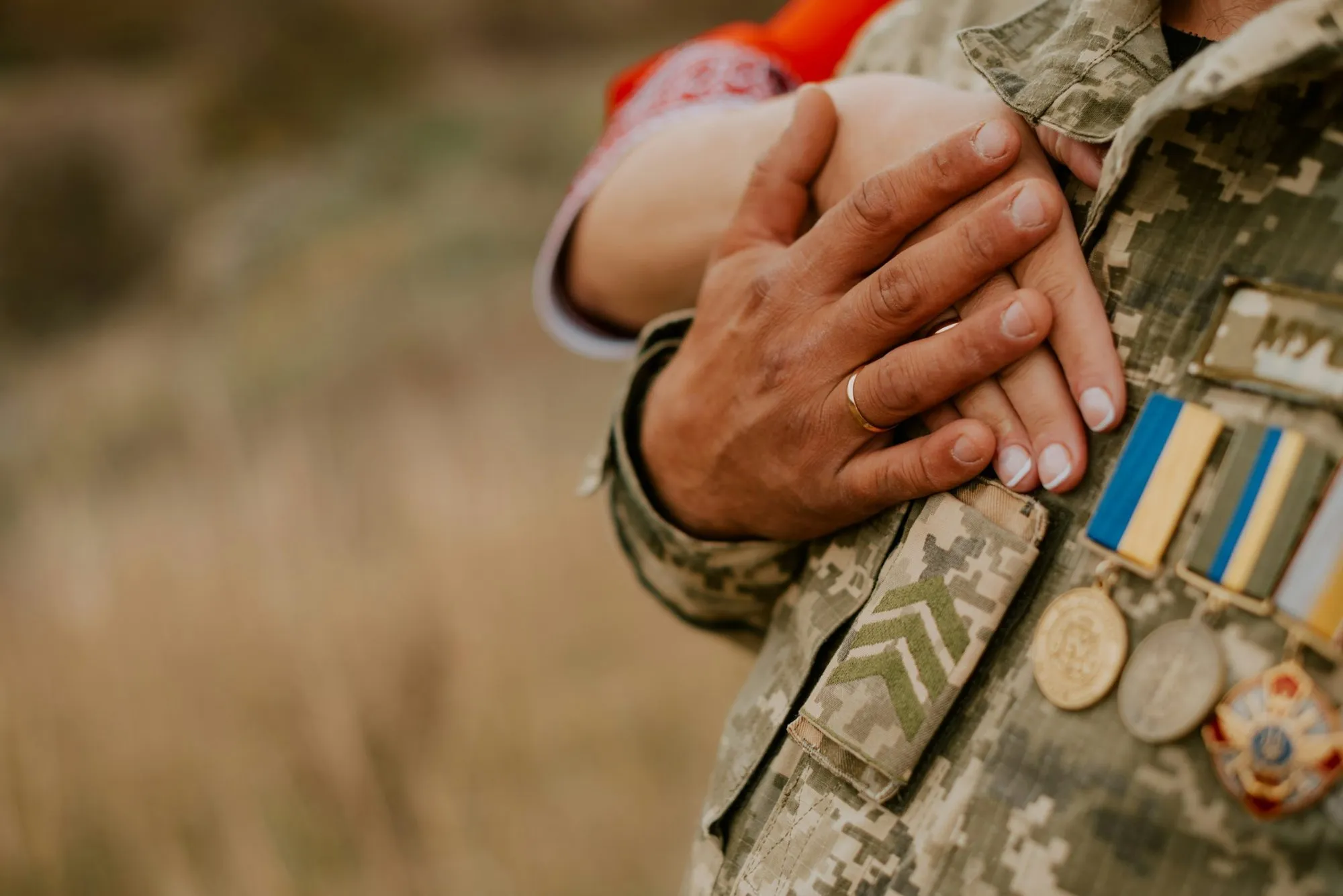 A service member and partner holding hands over a uniform